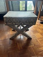 Front and side view of rectangular X-bench ottoman with cushioned top and X-shaped legs upholstered in black and white faux snakeskin fabric.