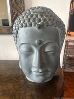 Front view of black resin Buddha head sculpture showing facial features and calm expression.
