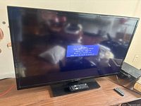 Front view of the 40-inch Insignia LED TV powered on, displaying a message about no signal input.