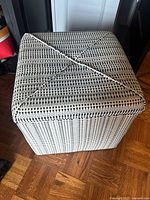 Top and sides of the square ottoman showing the black and white woven geometric pattern upholstery.