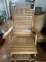 Front view of wooden lounge chair with slatted seat and backrest, curved armrests, and natural finish. Shows the adjustable back feature.
