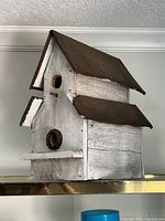 Front angled view showing distressed wood body and rusted metal roof