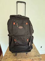 Front view of black Jaguar Sport Collection rolling duffel with handle extended