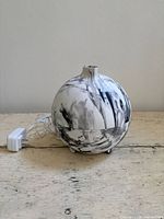 Front view of spherical white/black marble diffuser with adapter