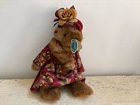 Full view of plush bear in dress and headwrap