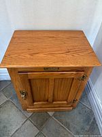Front view of oak ice box cabinet showing door and hardware