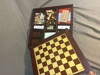 Open case showing internal trays with game components and detached chessboard lid