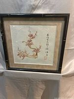 Full view of framed circular ink painting with mat and frame