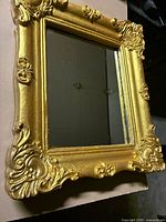 Front view of gold gilt mirror showing ornate frame and mirror glass