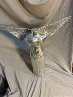 Front view of polished metal winged angel torso statue