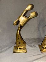 Front view of one sculpture, second partially visible