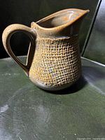 Side view of majolica corn pitcher showing relief texture and handle