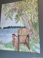 Full view of watercolor painting showing Adirondack chair by lake under tree