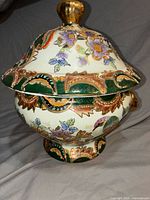 Front view of lidded footed bowl showing floral and green gilt design