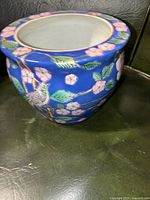 Full side view showing blue enamel ground with floral and bird motif