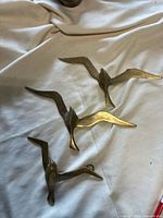 Three brass doves on cloth surface