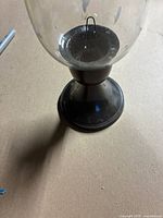 Full view of glass hurricane candle holder showing pedestal base and interior spike