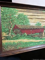 Full view showing red covered bridge, trees, wood frame