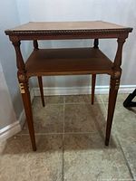 Front view of two-tier wooden side table showing overall design and proportion