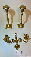 Wall sconce and two candlesticks displayed together