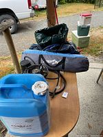 Overall view of camping items on table and coolers behind