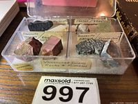 Close-up of plastic case with 8 labelled rock specimens