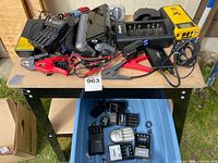 Overall lot on table and tote showing multiple chargers and boosters
