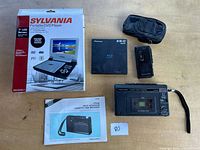 Full lot overview: Sylvania DVD player box, Pioneer Blu-ray drive, two cassette players, pouch, manual