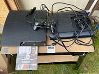 Top view showing PS3 console, DualShock controller, NASCAR 08 game case, camera bar and cables