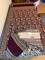 Full view of woven throw laid flat showing pattern and fringe