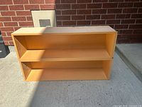 Front view of two-shelf wood veneer bookcase showing compartments and finish