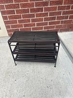 Front view of dark metal 3-tier shoe rack