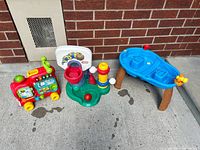 Group view of all three toys: activity train, basketball hoop set, water table