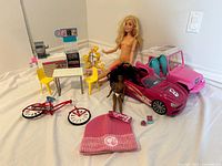 Overview of entire Barbie lot laid out: dolls, vehicles, café set, vanity, bicycle, hat and accessories