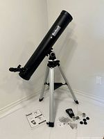 Full view of Bushnell telescope on tripod with accessories displayed