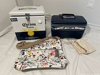 Group shot of Corona cooler, train case, floral bag, drawstring pouch