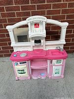 Front view of Step2 pink and white play kitchen showing all components