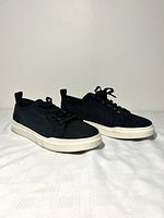 Side three-quarter view of both sneakers showing uppers, laces, and soles