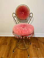 Full view of chair showing velvet upholstery, tassel trim and metal frame