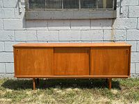 Straight-on front view of teak sideboard against wall