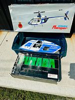 Photo of the Kavan Ranger helicopter box with the model fuselage inside a plastic container and the Futaba R/C system box below.