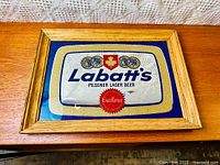 Full view of the framed advertising mirror showing the Labatt's Blue Pilsener Lager Beer logo with gold, blue, and red colors and natural wood frame.