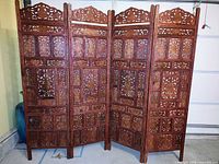 Front view of 4-panel carved wood room divider fully extended