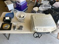Full view of printer covered with protective sheet, ink cartridges in container, two mice in bags, Dell mouse pad
