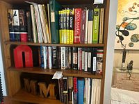 Three shelves of assorted books and DVDs