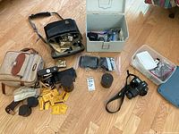 Overall view of cameras, lenses, film, and bags on floor