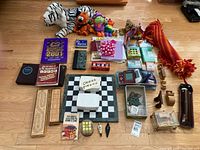 Full layout of lot showing plush toys, books, puzzles, chess board, cue case, throw blanket