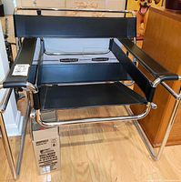 Front view of Wassily-style chair showing chrome frame and black leather-look panels