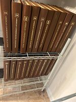 Two shelf rows of brown "American Commemorative Collections" binders, showing quantity and uniform condition