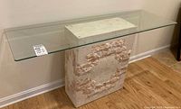 Front view of console table showing glass top and stone pedestal